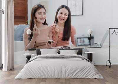 Beauty bloggers, two beautiful Asian women are trying to understand and sell cosmetics. Via online streaming from the camera With a happy smiling face, a new normal business Wall mural