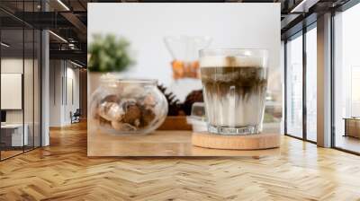 Japanese hojicha green tea drink is a latte in a glass placed on a wooden tray. Wall mural