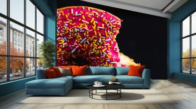 Close up shot of a pink donut isolated on black background Wall mural