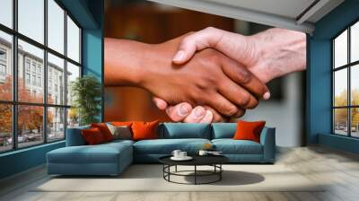 Two hands shake firmly in a gesture of agreement and friendship, symbolizing collaboration and unity in a diverse setting Wall mural