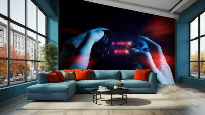 gamer boy with hand holding the joystick controller electronic for playing game with online network connection  technology device in esport tournament challenge concept Wall mural