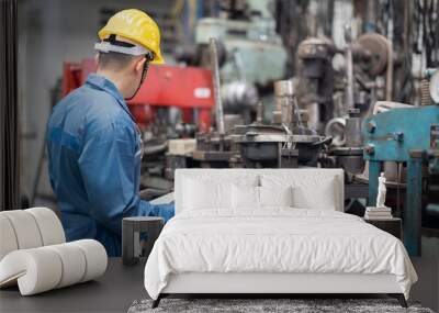 engineer checking metal component at machine receptacle in factory Wall mural