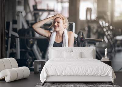 woman relaxing time after exercise on machine.Attractive builder muscles women in fitness gym Wall mural