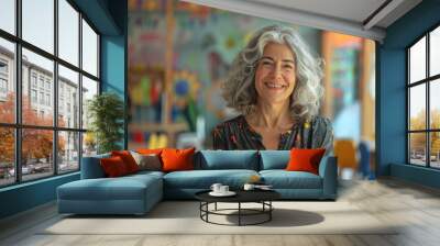 Middle age woman with grey hair preschool teacher smiling confident standing at kindergarten Wall mural