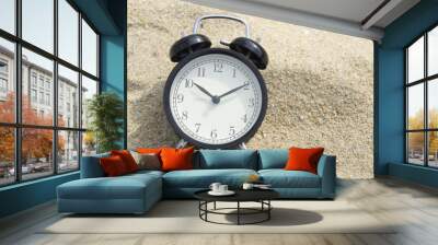 Black bell clock on the sand beach Wall mural