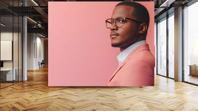 A young man in a pink suit and glasses looking to the side. Wall mural