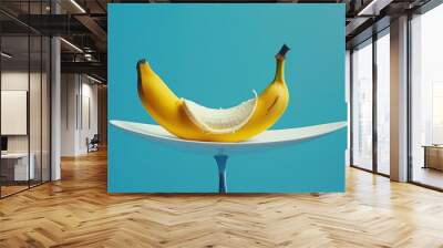 Partially Peeled Banana on a Plate with Blue Background. Wall mural