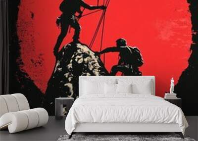 Two climbers silhouetted against a large red sun, one reaching down to help the other up a rocky cliff. Wall mural