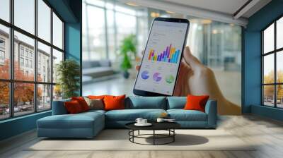 Hand holding smartphone displaying analytics chart Wall mural