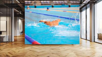 Athletic man swimming in butterfly style in the swimming pool with clear blue water. Wall mural