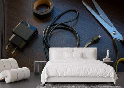 old mobile charger wire for smartphone with bare wires and electrical tape fix concept Wall mural