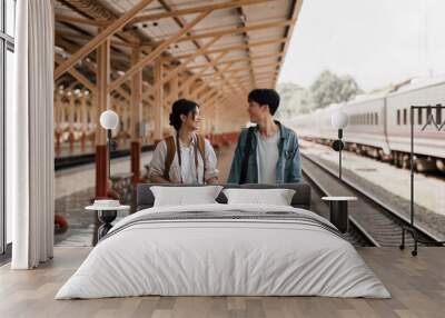 Asian couple at railway station have happy moment. Tourism and travel in the summer Wall mural