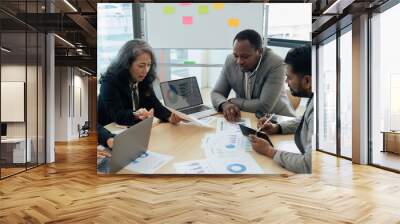 Female senior businessman brainstorming about marketing strategy report with diverse coworkers team Wall mural