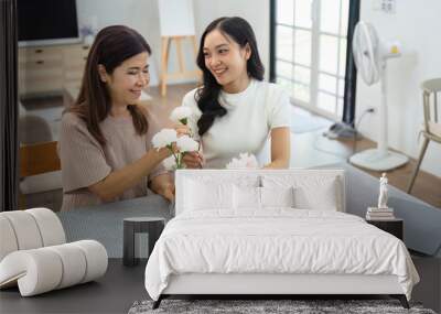 Mother and daughter arrange flower together at home on the weekend, family activities, mother and daughter do activities together on Mother's Day Wall mural