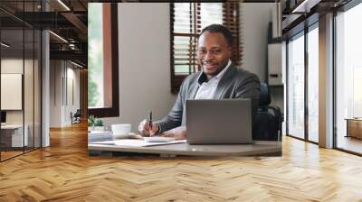 Smiling American African makes financial report and studies annual figures, analyzes profits. Accountant checks status of financial Wall mural