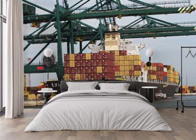 container ship at the dock in the harbor and be unloaded by large cranes. Wall mural