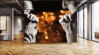 Praying man and woman with candles on background. Wall mural