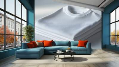 White t-shirt mockup folded neatly on a plain white surface, showing subtle creases and fabric detail Wall mural