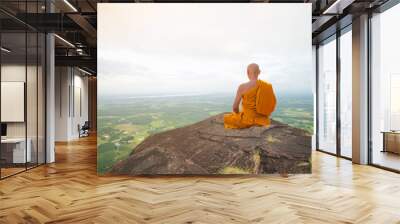 Buddhist monk in meditation at beautiful nature on high mountain Wall mural