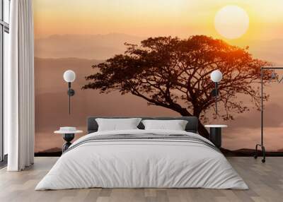 Buddhist monk in meditation under the tree at beautiful sunset or sunrise background Wall mural