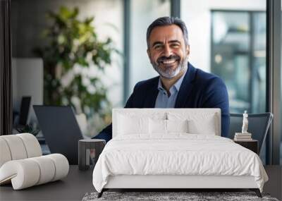 Portrait of a smiling  businessman sitting at a desk with a laptop in a modern office ,generative ai  Wall mural