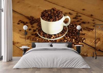 Coffee beans in a white cup on a wooden surface. Wall mural