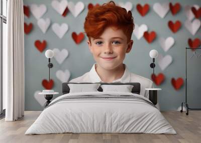 Valentine's Day, smiling red-haired boy on a background of red and white valentines. Atmosphere of joy and celebration Wall mural