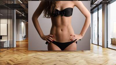 Woman in swimsuit with perfect abs, fit body Wall mural