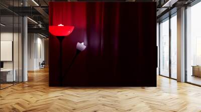 Floor lamp with red light in a dark room against the background of curtains. Wall mural