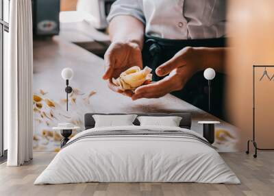 Chef woman's hands making tagliatelle pasta. Cooking process. Raw food photography concept. Wall mural