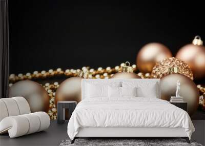 golden Christmas tree balls of bronze color with beads on a black background. a place to congratulate Wall mural