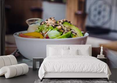 Green salad poke bowl with sesame dressing on a wooden table. Vegetarian raw meal concept Wall mural