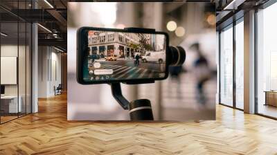 Man using phone with stabilizer and taking pictures and live video in New York city. Vlog, video blogging, street photography concept. Wall mural