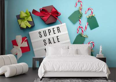 12.12 Super Sale text on white lightbox, with gift boxes and Christmas decorations on blue paper background. Wall mural