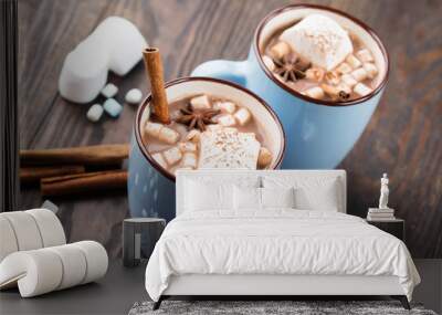 blue cups of hot chocolate drink with marshmallows and cinnamon on dark wooden background. winter ti Wall mural