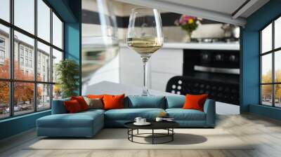 Two glasses of white wine on the kitchen table. Celebrate and enjoy the moment. Tasting of alcoholic beverages. Glass of wine close-up Wall mural