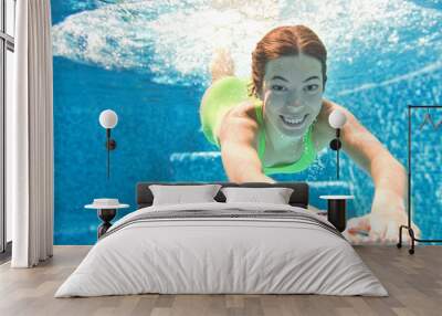 Child swims underwater in swimming pool, happy active teenager girl dives and has fun under water, kid fitness and sport on family vacation on resort
 Wall mural