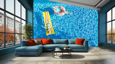 Children in swimming pool aerial drone view fom above, happy kids swim on inflatable ring donut and mattress, active girls have fun in water on family vacation on holiday resort
 Wall mural