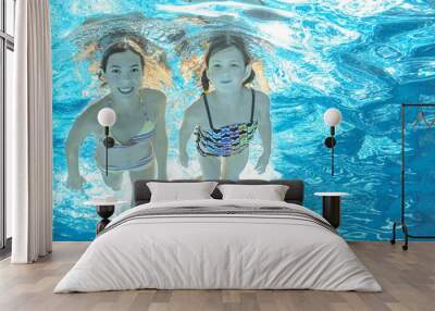 Children swim in pool underwater, happy active girls have fun in water Wall mural