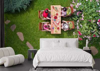 Family and friends eating together outdoors on summer garden party. Aerial view of table with food and drinks from above. Leisure, holidays and picnic concept
 Wall mural