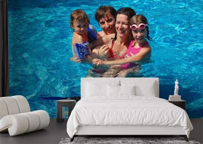 Happy family of four in swimming pool Wall mural