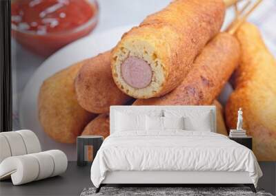 Corn dogs on white plate, served with ketchup, horizontal closeup Wall mural