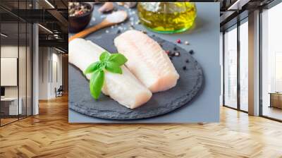 Fresh raw cod fillet with spices, pepper, salt, basil on stone plate, horizontal, copy space Wall mural