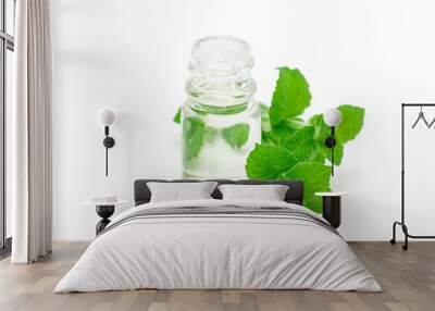 Peppermint essential oil in glass and fresh mint on background, isolated on white Wall mural