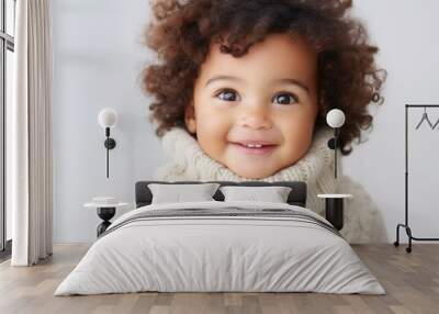 A joyful, cute boy looking at the camera in a studio setting. Wall mural