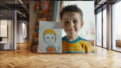 A young boy proudly holding a drawing of a smiling sun with arms and legs standing in a room with colorful artwork on the wall. Wall mural