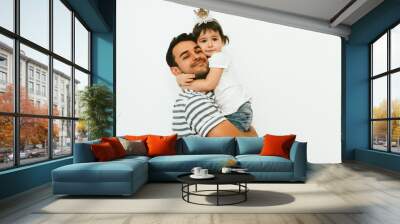 Happy relationship of handsome dad and cute daughter wearing crown play and embrace together against white background. Portrait of father and toddler girl celebrate and enjoy birthday together. Wall mural