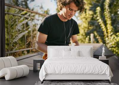 image of man with curly hair using laptop for chatting online with friends connected to free wireles Wall mural