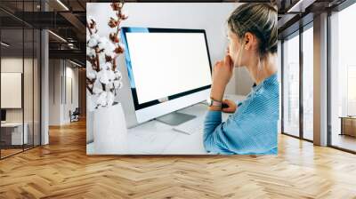 Side view of freelacer businesswoman using desktop computer in creative office. Photo of young blonde woman sit indoors at home working on computer with blank screen for your text message or content Wall mural