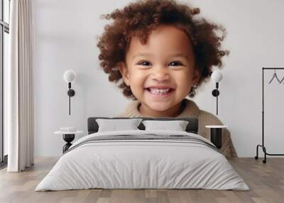 The pure delight of childhood in the smile of an African American toddler against a light beige backdrop. Wall mural